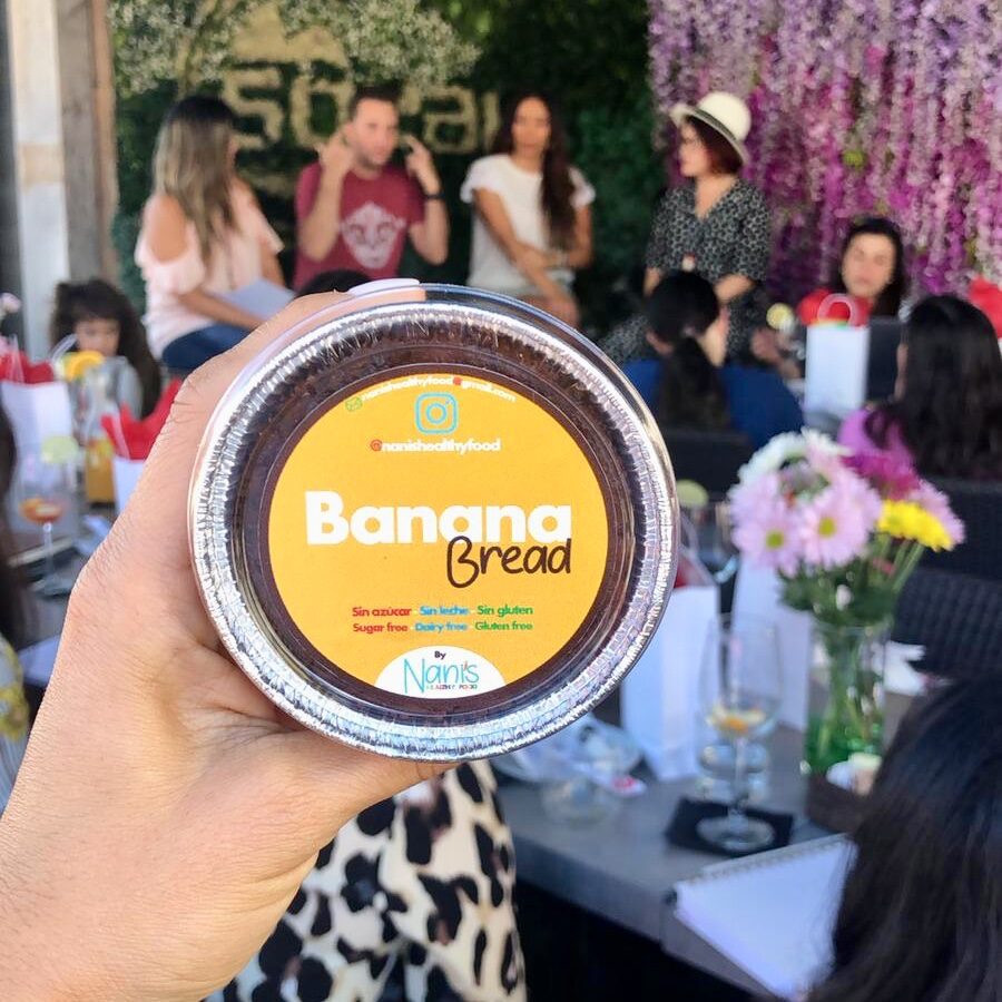 Hand holding a small container of banana bread