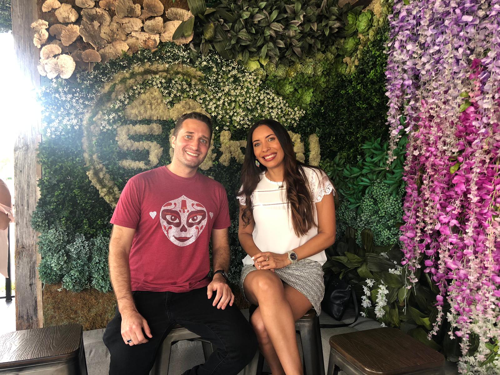 Alex Kassab and Lily Ramirez posing for a photo in front of a wall at Sokai Sushi Bar in The Falls